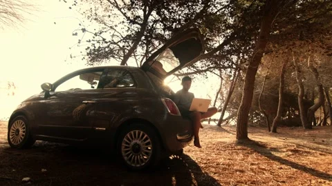 Car 3Man Sitting Cross-Legged at Car Trunk Working on Laptop Stock Footage 341939561