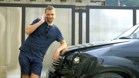 Car accident concept. man in a state of shock talking on the phone after a car Stock Footage 111489763