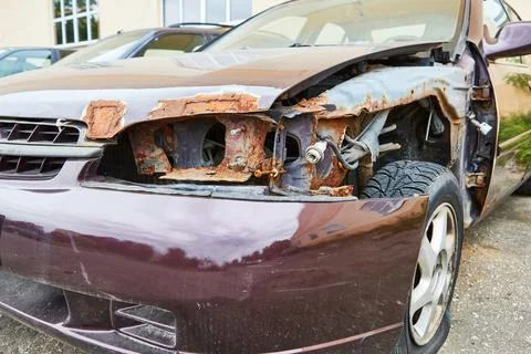 Car after the accident with rust without headlight and car fender close-up Stock Photos