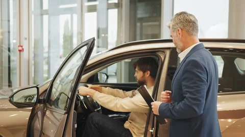 Car agent and customer in car showroom. Man choosing new car in salon. Car Stock Footage 240327630