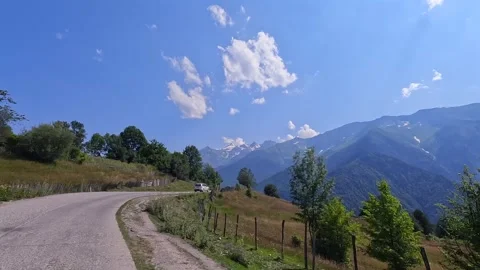 Car approaches Svaneti highlands, forward road view past wooden fencing Stock Footage 343774280