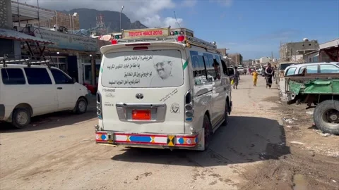 A car with an Arabic transcript crossing the street of Socotra, A kid Stock Footage 255873709