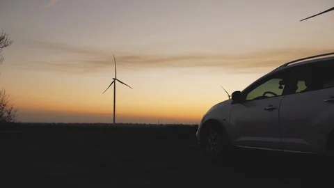 Car on the background of wind power stations at sunset Stock Footage 103219235