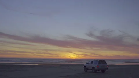 Car on the beach watches sunset Stock Footage 59989688