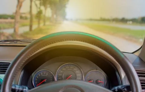 In the car behind the front steering wheel you can see the road in the morning. Stock Photos
