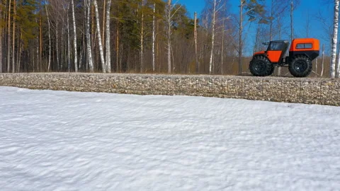 A car on big wheels driving along a coastal fortification. Frigid Expedition Stock Footage 262907882
