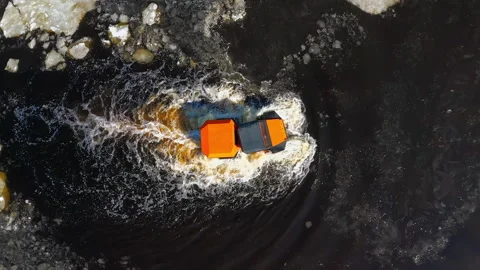 A car on big wheels is floating on water, with chunks of ice floating around Stock Footage 262908141