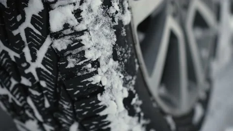 Car big wheels spin and spit up heavy wet snow as unknown driver tries to drive Stock Footage 233598243