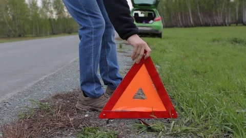 Car breakage. Guy sets a red triangle on the roadside Stock Footage 75919889