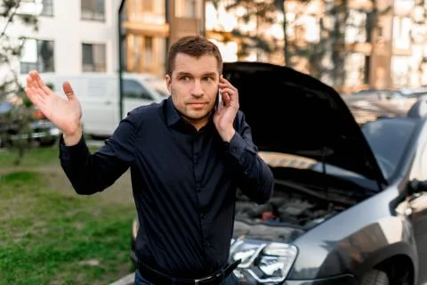 Car breakdown concept. The car will not start. A young man is calling for a car Stock Photos