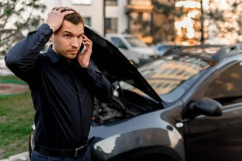 Car breakdown concept. The car will not start. A young man is calling for a car Stock Photos