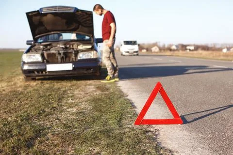 Car breakdown concept. Helpless man driver stands near brocken auto with op.. Stock Photos