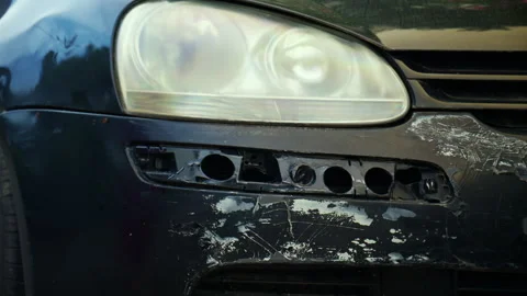 Car bumper showing significant damage, scratches, and a missing fog lamp cover Stock Footage 339783095