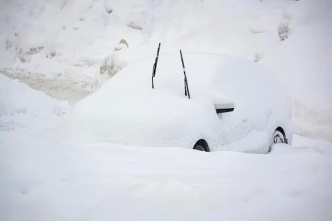 Car buried under a thick layer of snow after snow storm Stock Photos