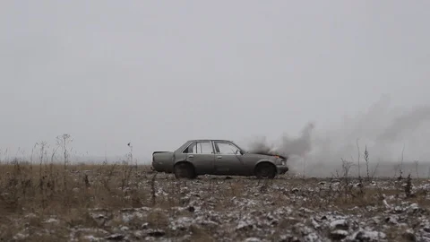A car with a burning engine is standing in an open field, cloudy weather Stock Footage 101529869