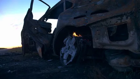 The car burns on the background of a blue sky after a fire Stock Footage 113483977