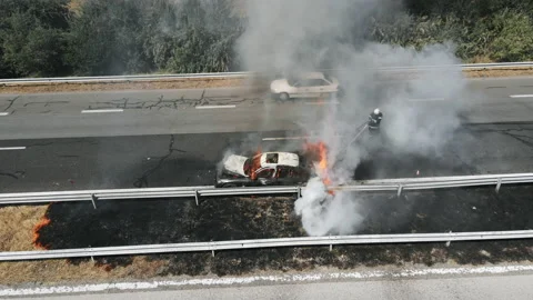 Car burns with big flame, black smoke on a major highway after a summer accident Stock Footage 142800260