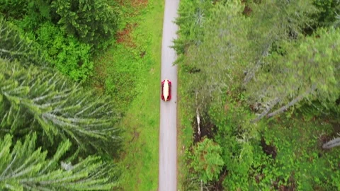 Car carrying a canoe passing through the forest Stock Footage 276387682
