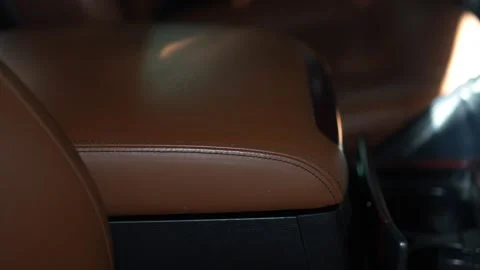 Car center console armrest upholstered in brown leather with black stitching. Stock Footage 344596651