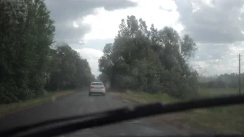 A car chases another car along a country road during a strong wind. Видео 144519094