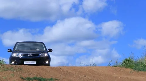 Car Chery Tiggo driving forward to the camera on dusty road, sky at abckground 스톡 동영상 47834535