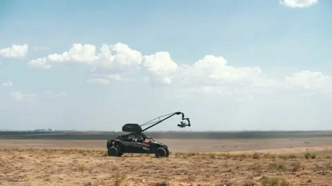 A car with a cinema camera mounted on a crane is driving across the steppe. Stock Footage 233671876