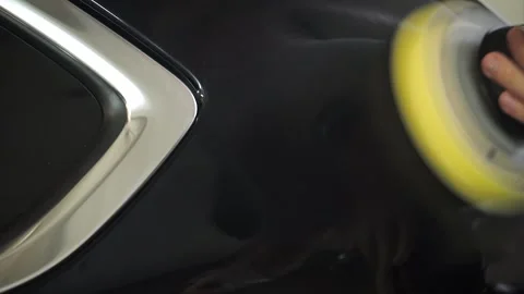 Car cleaning and detailing. A man in a garage polishes and washes a car. Close Stock Footage 174879040