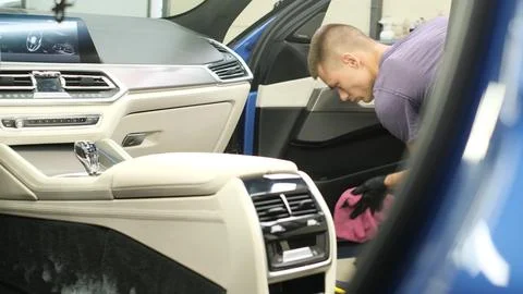 Car cleaning. Cleaning the leather elements in the car door. Stock Photos