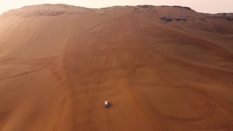 Car climbing up a dune in the desert Stock Footage 168360578