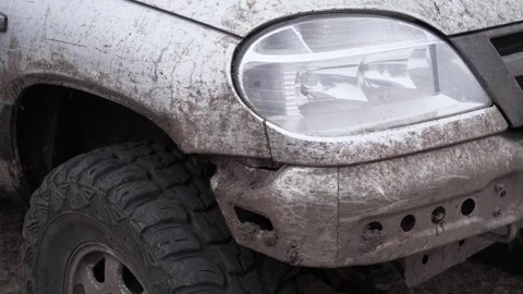 A car covered in mud is standing by the side of the road. Stock Footage 256158677