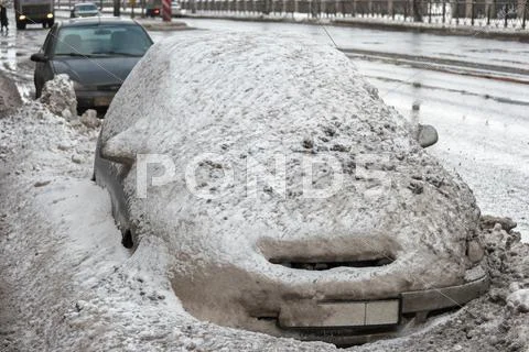 Car Covered With Old Mad Snow. Vehicle Covered With Snow In The Winter Blizzard