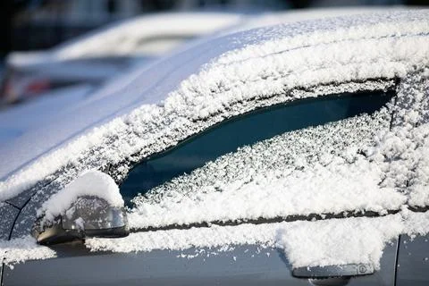 Car covered with a thin layer of fresh white snow. Side view. Fotos de archivo