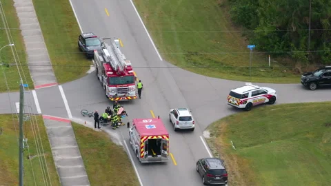 Car crash with first responders helping cyclist who was hit by car at accident Stock Footage 320085149