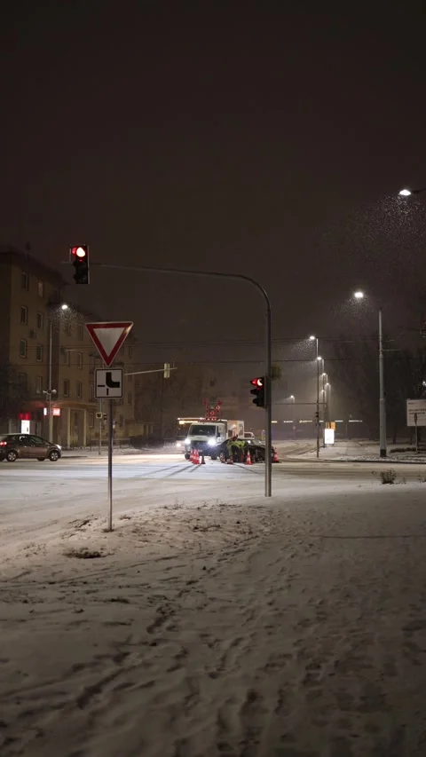 Car crash at snowy city intersection with emergency crew at night Stock Footage 326194527