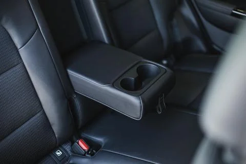 Car cup holders between back seats, close up view, luxury car interior Stock Photos