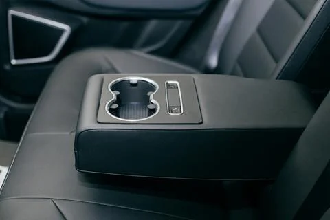 Car cup holders between back seats, close up view, luxury car interior Stock Photos