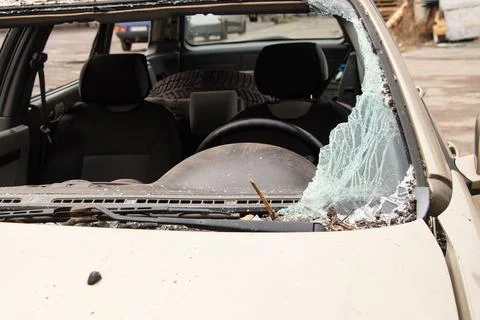A car damaged by a blast wave from a drone strike near a residential buildi.. Stock Photos