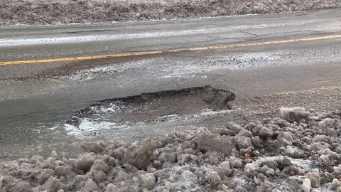 Car damaging large potholes on city streets Stock Footage 71335733