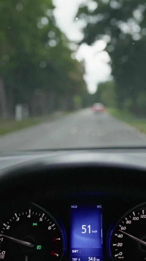 Car dashboard with digital speed display and blurred road ahead through Stock Footage 344773558