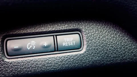 Car dashboard trip reset button on textured plastic panel Video stock 336661295