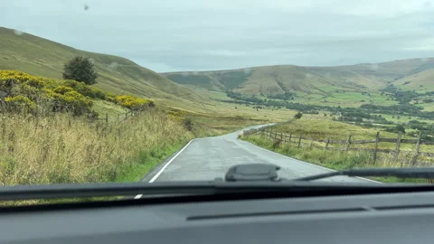 Car dashboard view driving down the hill in Peak District, England. Vídeos de archivo 345408309