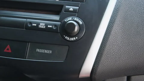 Car dashboard volume knob. Driver's hand adjusts Stock-Footage 246506612