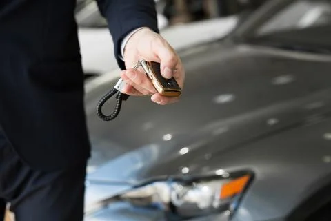 Car dealer with key close-up. Car sales at a car dealership Stock Photos