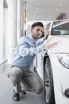 At The Car Dealer, Salesman Cleaning Car Wing