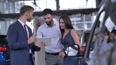 Car dealer using tablet to help buyers Video stock 146754876