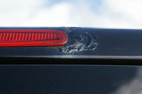 Car defect. Rust on the body of a black car near the brake light Stock Photos