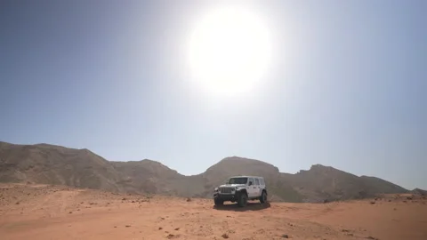Car in the desert with mountains in the background Video stock 201788939