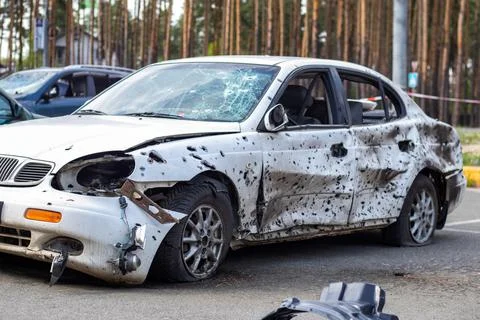 A car destroyed by shrapnel from a rocket that exploded nearby. Irpensky auto Stock Photos