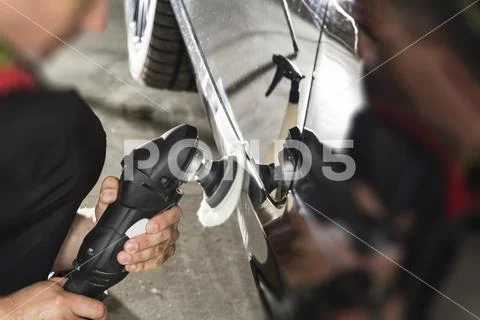 Car detailing - Hands with orbital polisher in auto repair shop. Selective fo Stock Photos