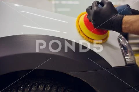 Car detailing - Hands with orbital polisher in auto repair shop. Selective focus Stock Photos